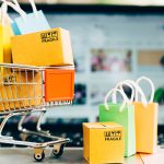 Product package boxes and shopping bag in cart with laptop compu